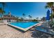 Community swimming pool with lounge chairs, umbrellas, and lush tropical landscaping at 6000 Boca Grande Cswy # D46, Boca Grande, FL 33921