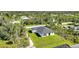 An aerial view showcases a modern home with manicured lawns and lush trees on a private homesite at 9262 Genesee St, Port Charlotte, FL 33981
