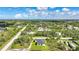 A landscape aerial photo reveals a single house situated in a green community surrounded by mature trees at 9262 Genesee St, Port Charlotte, FL 33981