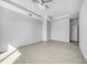 Spacious bedroom with tile flooring, a modern ceiling fan, and a classic double-door closet at 9262 Genesee St, Port Charlotte, FL 33981