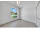 An empty bedroom with light tile flooring, a large window, and a closet with full-sized door at 9262 Genesee St, Port Charlotte, FL 33981
