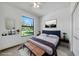 A staged bedroom with light tile flooring, a large window, and a closet with full-sized door at 9262 Genesee St, Port Charlotte, FL 33981