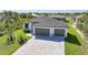 An elevated view showcases a modern home with a three-car garage and lush landscaping at 9262 Genesee St, Port Charlotte, FL 33981