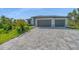 Stunning single-story home boasts a lush landscaped yard and three-car garage with a stone-accented facade at 9262 Genesee St, Port Charlotte, FL 33981