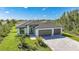 Aerial view of a modern home with a well-manicured lawn, and a spacious driveway and three-car garage at 9262 Genesee St, Port Charlotte, FL 33981