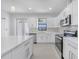 Bright white kitchen with stone countertops, stainless steel appliances, and large center island at 9262 Genesee St, Port Charlotte, FL 33981