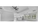 Bright living space boasts modern fan, tray ceiling, and large windows, with access to the kitchen at 9262 Genesee St, Port Charlotte, FL 33981