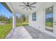 A covered patio features tiled floors, an installed ceiling fan, and a view of the backyard and surrounding landscape at 9262 Genesee St, Port Charlotte, FL 33981