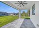 A covered patio features tiled floors, an installed ceiling fan, and a view of the backyard and nearby homes at 9262 Genesee St, Port Charlotte, FL 33981