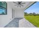 A covered patio features tiled floors, an installed ceiling fan, and a view of the backyard at 9262 Genesee St, Port Charlotte, FL 33981