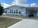 Light blue single-wide manufactured home with covered carport and landscaped yard at 6432 Keena Ct, North Port, FL 34287