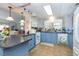 Kitchen with blue cabinets, granite counters, and modern appliances at 6432 Keena Ct, North Port, FL 34287