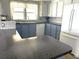 Kitchen boasts blue cabinets, granite countertops, and a dishwasher at 6432 Keena Ct, North Port, FL 34287