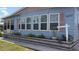 Light blue single-wide manufactured home with a landscaped yard and covered carport at 6432 Keena Ct, North Port, FL 34287