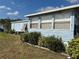Side view of a light blue single-wide manufactured home with landscaping at 6432 Keena Ct, North Port, FL 34287