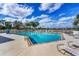 Community pool with surrounding lounge chairs and lake view at 2024 Lynx Run, North Port, FL 34288