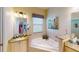 Elegant bathroom with corner bathtub, granite countertops and double sinks at 417 Tomoka Dr, Englewood, FL 34223