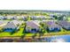 Aerial view of a community with houses and a pond at 417 Tomoka Dr, Englewood, FL 34223