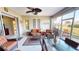 Bright sunroom with wicker furniture, ceiling fan and view of the backyard at 417 Tomoka Dr, Englewood, FL 34223