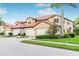 Tan townhome with three-car garage and lush landscaping at 23516 Awabuki Dr # 5-201, Venice, FL 34293