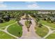 Aerial view of community entrance with lush landscaping and guard house at 23516 Awabuki Dr # 5-201, Venice, FL 34293