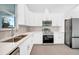 Modern kitchen with white cabinets, stainless steel appliances, and herringbone backsplash at 9262 Genesee St, Port Charlotte, FL 33981