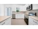 Modern kitchen with white cabinets, herringbone backsplash, and stainless steel appliances at 9262 Genesee St, Port Charlotte, FL 33981