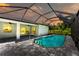 Evening view of the pool and patio area with screened enclosure at 204 Cougar Way, Rotonda West, FL 33947