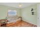 Bedroom with wood flooring, pull-out sofa, and wall-mounted TV at 64 Long Meadow Ln, Rotonda West, FL 33947