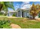 Single-story home with light blue exterior, landscaping, and attached garage at 64 Long Meadow Ln, Rotonda West, FL 33947