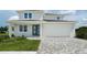 Two-story home with gray paver driveway and landscaped lawn at 5240 Willow Lake Ct, Sarasota, FL 34233