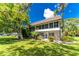 Two-story condo building with screened patio, lush landscaping, and grassy lawn at 3 Quails Run Blvd # 8, Englewood, FL 34223