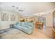 Open living space with light floors and blue couch, view of kitchen and dining area at 9273 Carnation Ave, Englewood, FL 34224
