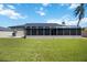 Enclosed patio area attached to the house with grassy backyard at 9273 Carnation Ave, Englewood, FL 34224