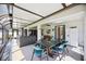 Sunroom with dining table and comfortable seating area, overlooking the backyard at 9273 Carnation Ave, Englewood, FL 34224