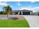 House exterior with palm tree, driveway, and landscaping at 9273 Carnation Ave, Englewood, FL 34224