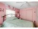 Second bedroom with a queen bed, ceiling fan, and pink walls at 130 Nautical Dr, North Port, FL 34287