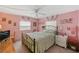 Guest bedroom with a queen bed, ceiling fan, and pink walls at 130 Nautical Dr, North Port, FL 34287
