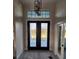 Elegant foyer with high ceilings, decorative glass double doors, chandelier and neutral decor at 10454 Atenia St, Port Charlotte, FL 33981