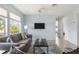 Living room with gray sofa, TV, and light blue walls at 2375 N Beach Rd # 3A, Englewood, FL 34223