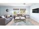 Bright living room with comfy sofas, large windows, and a coffee table at 2375 N Beach Rd # 3A, Englewood, FL 34223