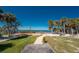 Scenic beach path surrounded by palm trees leading to the waterfront at 470 S Mccall Rd # 10, Englewood, FL 34223