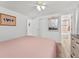 Bedroom features flamingo art, wood-look floors, and attached bathroom with tile surround at 470 S Mccall Rd # 10, Englewood, FL 34223