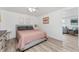 Bedroom with wood-look floors, light gray walls, and pastel pink bedding; door to a living area is visible at 470 S Mccall Rd # 10, Englewood, FL 34223