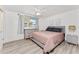 Bright bedroom features wood-look floors, a ceiling fan, and decor with a splash of pastel pink at 470 S Mccall Rd # 10, Englewood, FL 34223