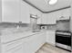 Modern kitchen with white cabinetry, stainless steel appliances, and elegant backsplash at 470 S Mccall Rd # 10, Englewood, FL 34223