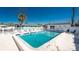 Community pool surrounded by a white fence and lounge chairs on a sunny day at 470 S Mccall Rd # 10, Englewood, FL 34223