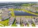 Aerial view displays homes near a pond, highlighting the community's landscaping and serene water feature at 7537 Pool Compass Loop, Wesley Chapel, FL 33545