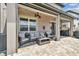Covered patio boasts stylish wicker furniture, string lights, and a cozy outdoor living space at 7537 Pool Compass Loop, Wesley Chapel, FL 33545