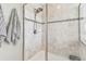 Modern tiled shower with glass enclosure and decorative accent strip at 7537 Pool Compass Loop, Wesley Chapel, FL 33545